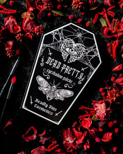 Deadly Sins Cosmetics 'Dead Pretty' eyeshadow palette with moths and spider web design on a dark background with red a gothic style.