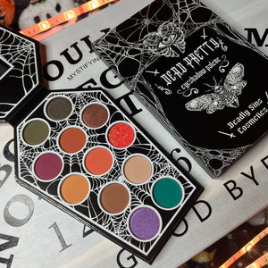 Deadly Sins Cosmetics 'Dead Pretty' eyeshadow palette with moths and spider web design on a dark background with red a gothic style.